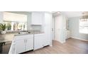 Bright kitchen featuring white cabinets, gray countertops, and laminate flooring at 726 Viking Ave, Tavares, FL 32778
