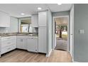 Bright kitchen showcases white cabinets, updated appliances, and a large window offering pleasant outdoor views at 726 Viking Ave, Tavares, FL 32778