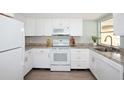 Inviting kitchen featuring white appliances, gray countertops, and laminate flooring at 726 Viking Ave, Tavares, FL 32778