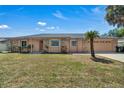 Well maintained home with tan and brick exterior, lush lawn, and a large garage, perfect for Gathering living at 8720 Larwin Ln, Orlando, FL 32817