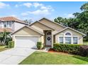 Charming single-story home featuring a well-manicured lawn, two-car garage, and inviting front entrance with arched window at 150 Golfside Cir, Sanford, FL 32773