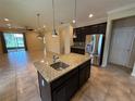 Modern kitchen island boasts granite countertops, stainless steel appliances and pendant lighting at 2815 Moonstone Bnd, Kissimmee, FL 34758