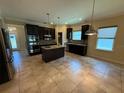 Spacious kitchen features dark cabinetry, stainless steel appliances, and an island with granite countertops at 2815 Moonstone Bnd, Kissimmee, FL 34758