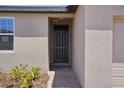 Close-up of a modern home entrance featuring a sleek black door and brick-paved walkway at 3218 Viceroy Ct, Poinciana, FL 34759