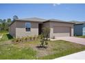 Single-story home with a two-car garage, minimal landscaping, and a brick-paved walkway at 3218 Viceroy Ct, Poinciana, FL 34759
