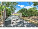 Long driveway leading to a property with lush greenery, trees, and an open, spacious area at 4570 Chambliss Rd, Winter Haven, FL 33884
