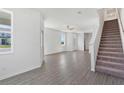 Spacious living room features wood floors, a ceiling fan, and staircase at 818 Poppy Ln, Dundee, FL 33838