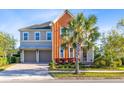 Beautiful exterior view of a two story home with a brick driveway and a large palm tree at 9254 Reymont St, Orlando, FL 32827