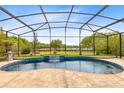 A luxurious backyard screened-in pool features a tranquil waterfall and landscaping at 9254 Reymont St, Orlando, FL 32827