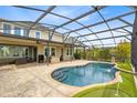 A luxurious backyard screened-in pool features a tranquil waterfall and steps for easy access at 9254 Reymont St, Orlando, FL 32827
