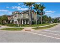 Attractive townhouse with a well-kept lawn, palm trees, and a red front door at 1197 Tallow Rd, Apopka, FL 32703