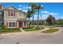 Charming townhouse featuring a red door, well-maintained landscaping, and a covered porch at 1197 Tallow Rd, Apopka, FL 32703
