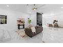 Open-concept living room with white marble floors, modern furnishings, and a stylish black accent wall at 305 Sweetwater Club Cir, Longwood, FL 32779