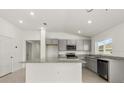 Modern kitchen features gray cabinets, stainless steel appliances, and a granite countertop island with a window at 644 Royal Palm Dr, Dundee, FL 33838