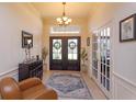 Welcoming foyer featuring a tiled floor, elegant double doors, neutral paint, and decorative lighting for a grand entrance at 11314 Ledgement Ln, Windermere, FL 34786
