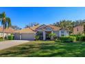 Charming single-story home with a three-car garage, manicured landscaping, and a tiled roof in a sunny neighborhood at 11314 Ledgement Ln, Windermere, FL 34786