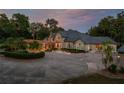 Beautiful home with well-manicured landscaping, a circular driveway, and an attractive water fountain at 11450 Nellie Oaks Bnd, Clermont, FL 34711