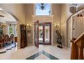 Elegant foyer with an ornate front door, high ceilings, and exquisite tile flooring at 11450 Nellie Oaks Bnd, Clermont, FL 34711