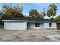 Single-story home with a two-car garage, light blue exterior, modern windows, and simple landscaping at 13075 Se 35Th Ct, Belleview, FL 34420