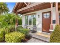 Welcoming front porch with chairs, lush greenery and a decorative door at 1601 Chestnut Ave, Winter Park, FL 32789