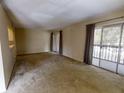 Spacious carpeted living room with natural light from sliding doors to balcony at 190 Hickory Woods Ct # 1B, Deltona, FL 32725