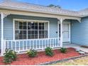 A cozy front porch with decorative trim, well kept flower bed and beautiful landscaping at 2617 Greywall Ave, Ocoee, FL 34761