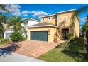 A two-story home with a brick driveway, two-car garage, well-manicured lawn, and neutral paint at 291 Pendant Ct, Kissimmee, FL 34747