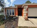 Inviting front entrance with decorative accents, complemented by a well-maintained walkway and garden bed at 3020 Norlina St, Deltona, FL 32738