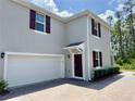 Two-story home with an attached two-car garage and brick-paved driveway at 3024 Meleto Blvd, New Smyrna Beach, FL 32168