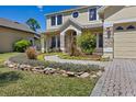 Charming two-story home featuring a paver walkway, stone accents, and lush landscaping at 3428 Deer Oak Cir, Oviedo, FL 32766