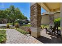 Cozy front porch seating area with brick columns, landscaping, and a view of the neighborhood at 3428 Deer Oak Cir, Oviedo, FL 32766