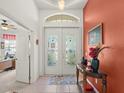 Inviting foyer with tiled floor, decorative double doors, and accent wall with elegant decor at 4918 Oakway Dr, St Cloud, FL 34771