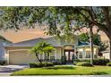 Inviting one-story home with mature trees, lush landscaping and a classic façade under a beautiful sky at 4918 Oakway Dr, St Cloud, FL 34771