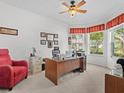 Bright office space with large windows, a ceiling fan, and a cozy red chair at 4918 Oakway Dr, St Cloud, FL 34771
