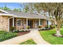 Inviting front porch with rocking chairs and decorative plants, leading to a classic brick facade home at 528 Woodview Dr, Longwood, FL 32779