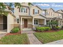 Charming tan two-story townhome with landscaped yard and brick walkway at 5892 Soter Ln, Windermere, FL 34786