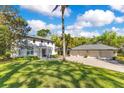 Exterior elevation features a spacious lawn, a home, and a detached three car garage at 6082 Twin Lakes Dr, Oviedo, FL 32765