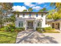 An attractive home features lush landscaping and a welcoming entrance with grey brick walkway at 6082 Twin Lakes Dr, Oviedo, FL 32765