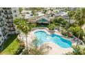 Relaxing pool with spa and plenty of lounge chairs surrounded by palm trees and well-manicured landscaping at 6165 Carrier Dr # 3602, Orlando, FL 32819