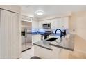 Well-lit kitchen equipped with stainless steel appliances, white cabinets and stylish countertops at 692 Seabrook Ct # 103, Altamonte Springs, FL 32714