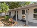 Inviting front porch area with seating, plants, a brick pathway, and the house number displayed at 80 Lombardy Rd, Winter Springs, FL 32708
