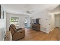 Cozy living room with hardwood floors, ceiling fan, and a comfortable recliner near the door at 80 Lombardy Rd, Winter Springs, FL 32708