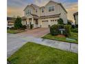 Charming two-story home with a brick driveway, well-maintained lawn, and lovely landscaping at 8225 Corkfield Ave, Orlando, FL 32832
