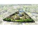 Aerial view of a secluded home nestled among a lush green canopy and bordered by serene lake and fountain feature at 835 Dyson Dr, Winter Springs, FL 32708