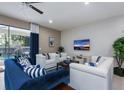 Bright living room with blue and white furniture, large sliding glass doors and a mounted television at 8892 Bengal Ct, Kissimmee, FL 34747