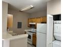 Bright kitchen with white appliances, wooden cabinets and tile backsplash at 9021 Lee Vista Blvd # 1707, Orlando, FL 32829