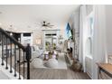 View of living room with fireplace, wood floors, large windows, and adjacent kitchen area at 903 Sydney St, Davenport, FL 33837