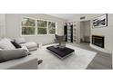 Bright living room showcasing sleek furniture, a large window view, and a cozy fireplace, all bathed in natural light at 239 S Lake Cortez Dr, Apopka, FL 32703