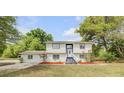 Charming two-story home with manicured lawn, blue trim, and inviting staircase leading to the front entrance at 2550 Barren Oak Ct, Deland, FL 32720