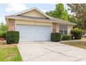 Home featuring an attached two-car garage and driveway with a well-manicured lawn at 321 Moffat Loop, Oviedo, FL 32765
